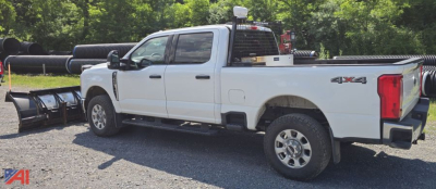 Ford F-350 Super Duty XLT Crew Cab with plow and 4x4 badge, side view showing plow mount, bed toolboxes, and dual rear wheels.