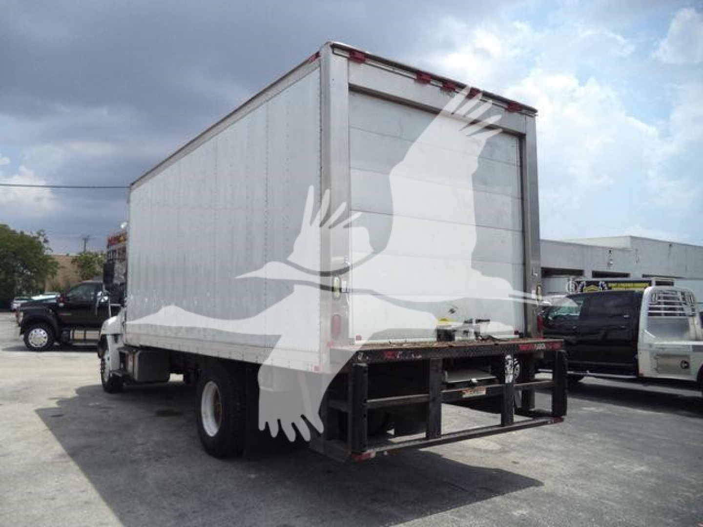 Truck rear view of a 2015 Hino 268A refrigerated box truck showing cargo box and rear doors.