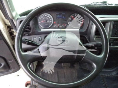 Dashboard view of a 2015 Hino 268A refrigerated truck interior, steering wheel centered, gauges, drivetrain controls visible.