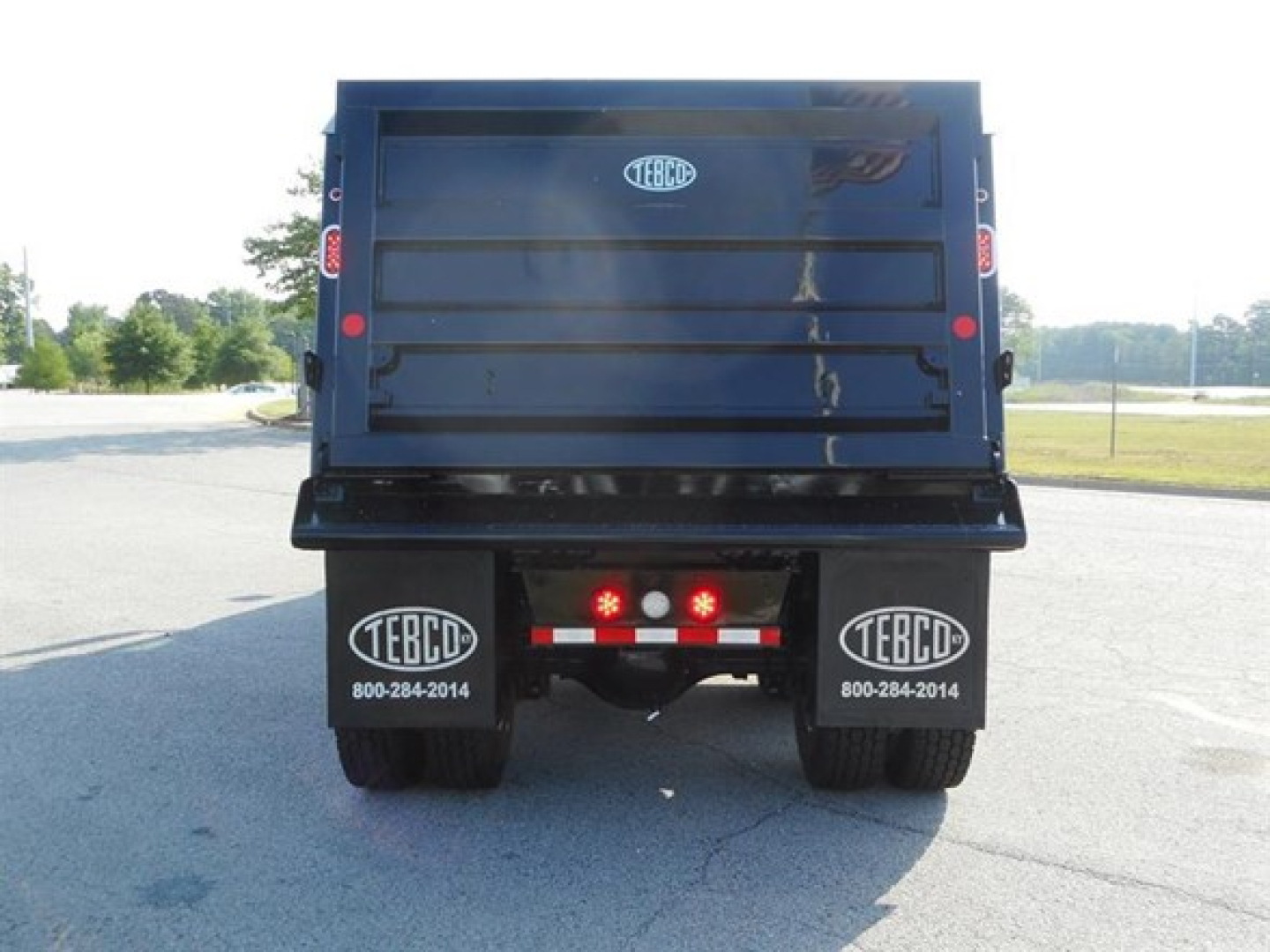 Rear view of a new Western Star 47X dump truck showing TEBC branding on mud flaps and taillights.