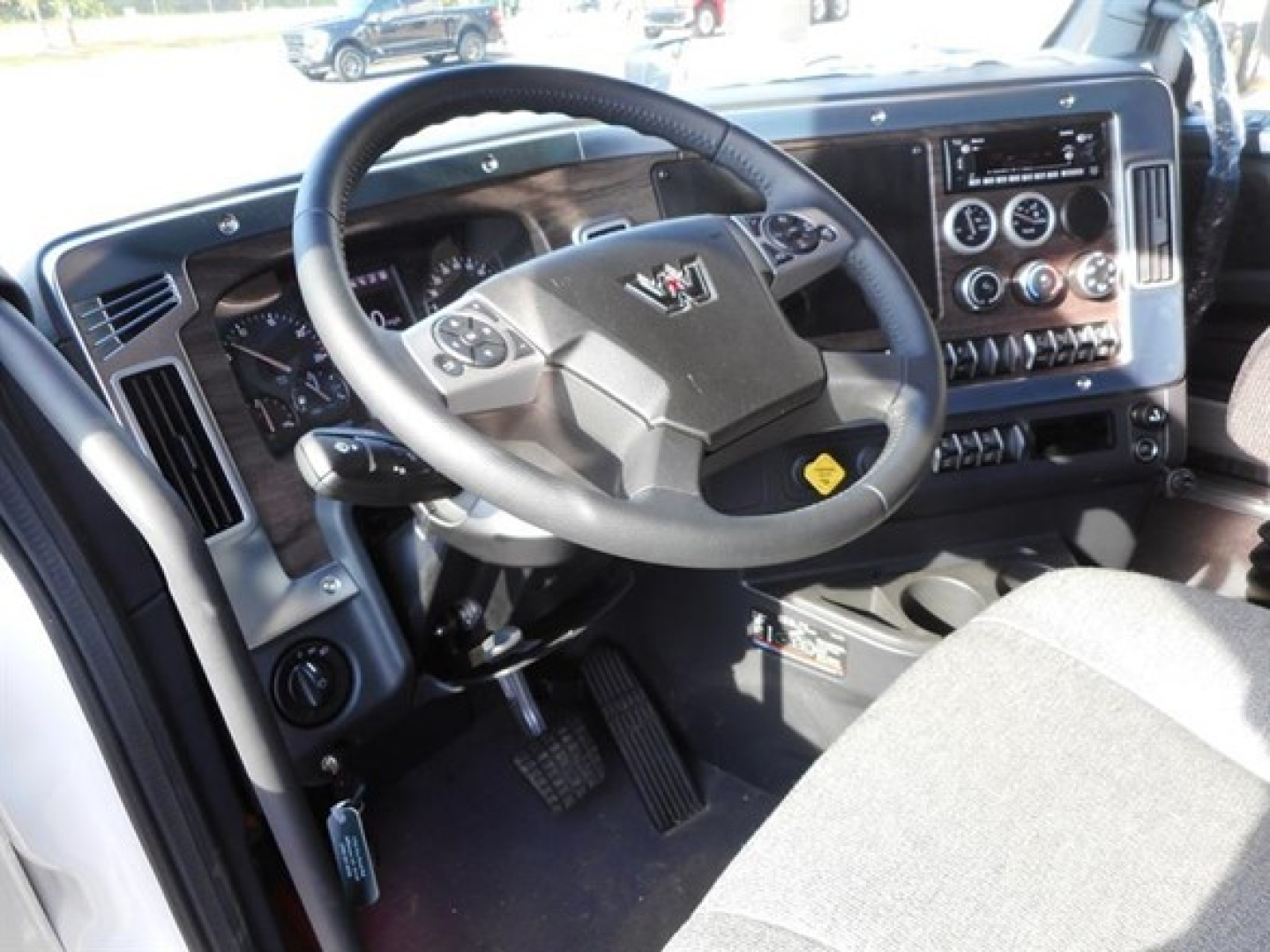 Truck interior showing steering wheel, dashboard with gauges, and center console of a Western Star 47X cab.