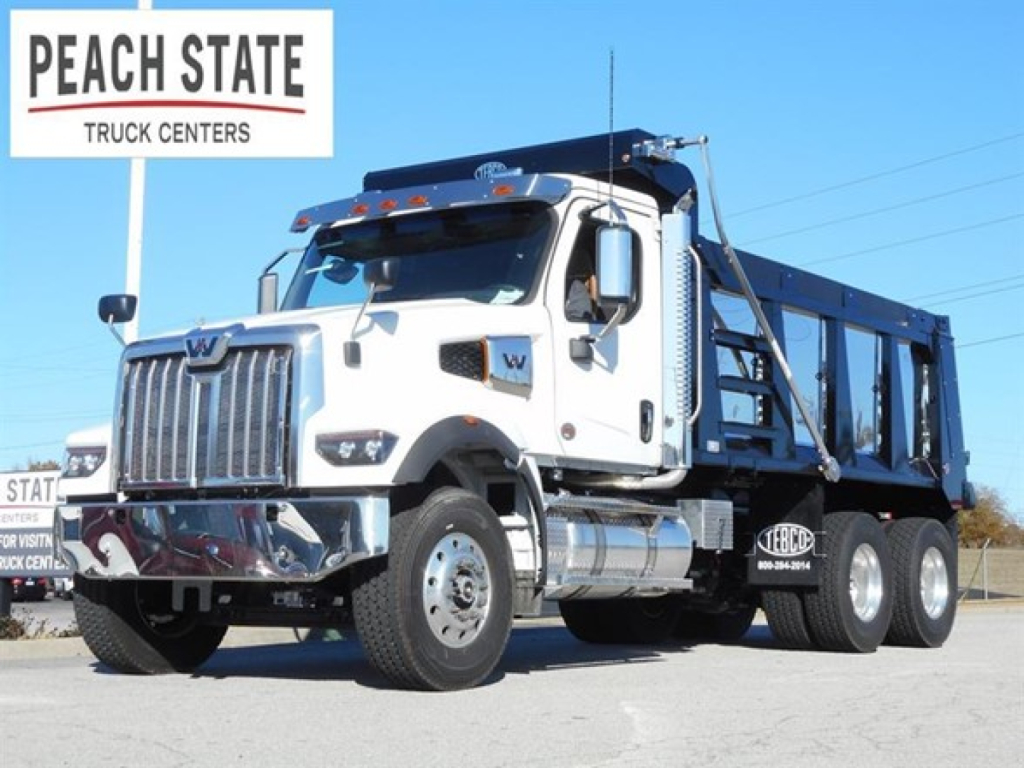 Western Star 47X dump truck in white cab with blue dump bed, side view showing Peache State Truck Centers signage.
