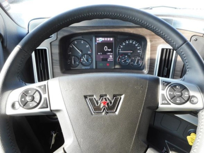 Truck cabin steering wheel and instrument cluster with Western Star logo on the steering wheel; dashboard controls visible.
