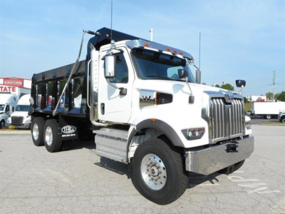 Western Star 47X dump truck in white, front three-quarter view showing chrome grille, large bumper, dual rear wheels, and dump bed with side rails.