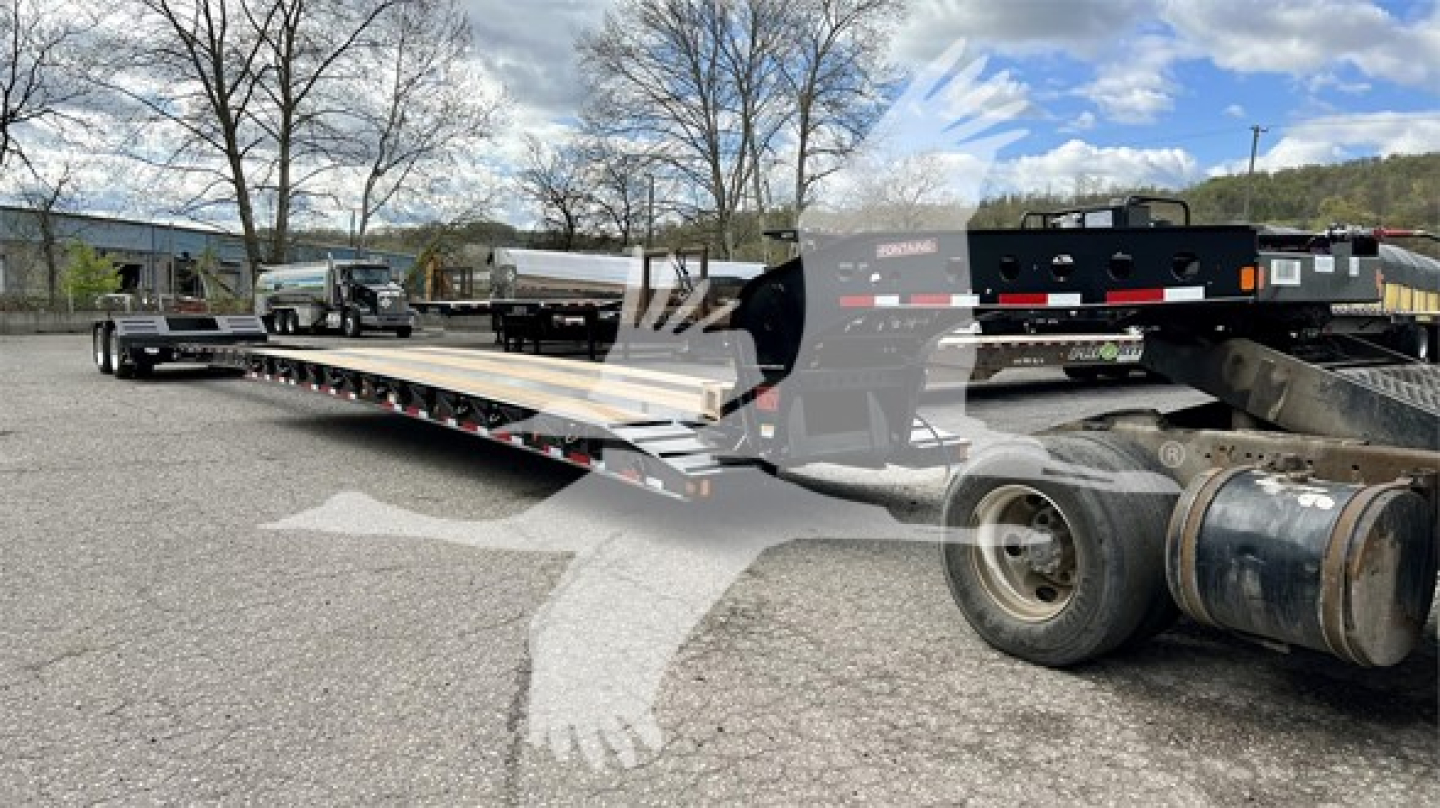 Trailer showing a Fontaine Renegade lowboy trailer with long deck and gooseneck, side rails, and dual rear axles; visible tires and equipment in yard.