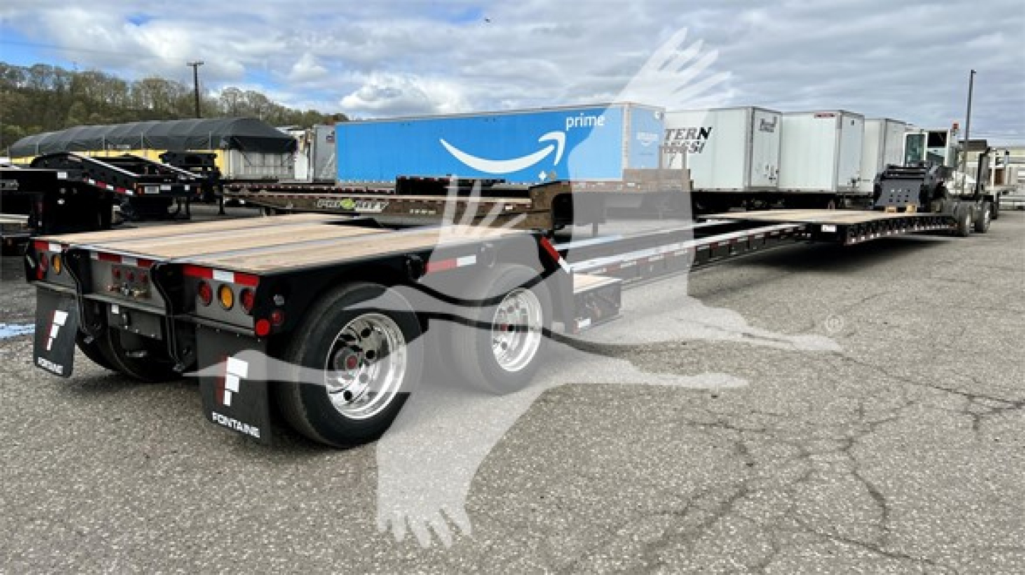 Fontaine Renegade Xn20 lowboy trailer rear and mid section showing dual rear axles, heavy-duty tires, and reflective mud flaps.