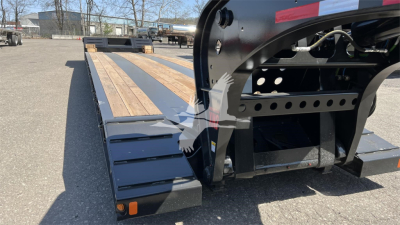 Lowboy trailer deck showing wooden boards on Fontaine XN20 with hydraulic framework and tandem hitch in view.