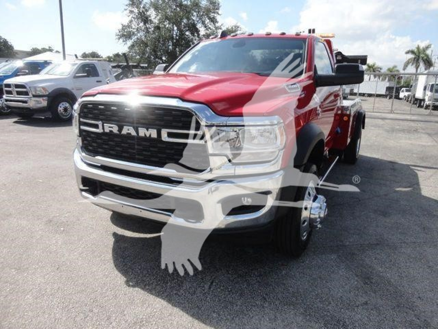 Truck front view of a red 2024 Ram 4500 SLT in a lot, with large grille, RAM lettering on the grille, dual rear wheels visible, and a winch category listing in the context.