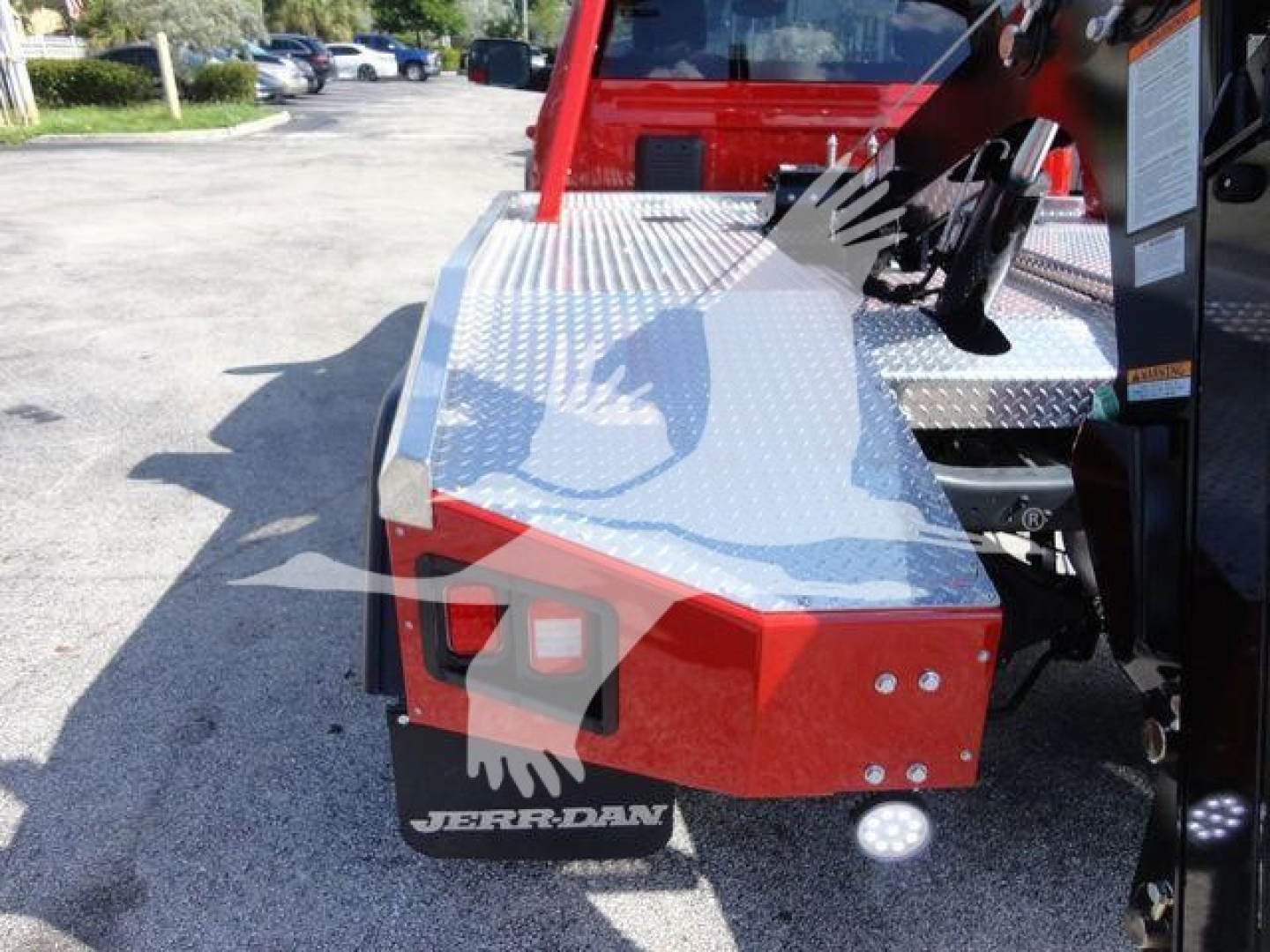 Ram 4500 truck bed with diamond plate aluminum storage and winch equipment, red rear bumper, Jerr-Dan logo visible.