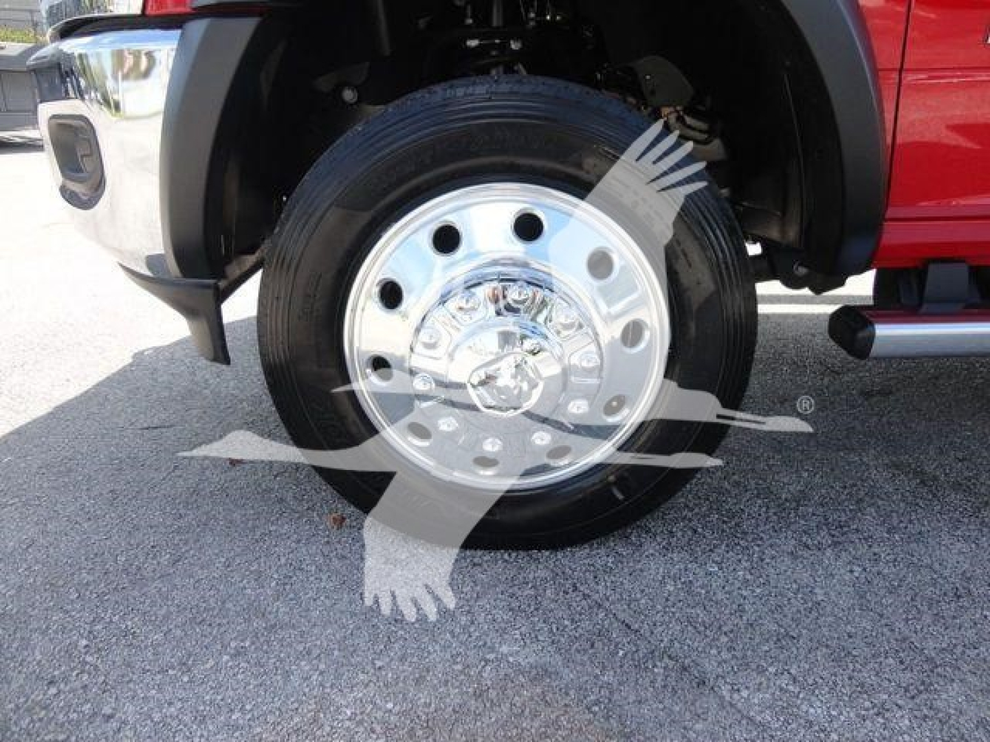 Truck wheel with chrome hubcap and black tire on front fender; partial red body of Ram 4500 pickup and chrome bumper visible