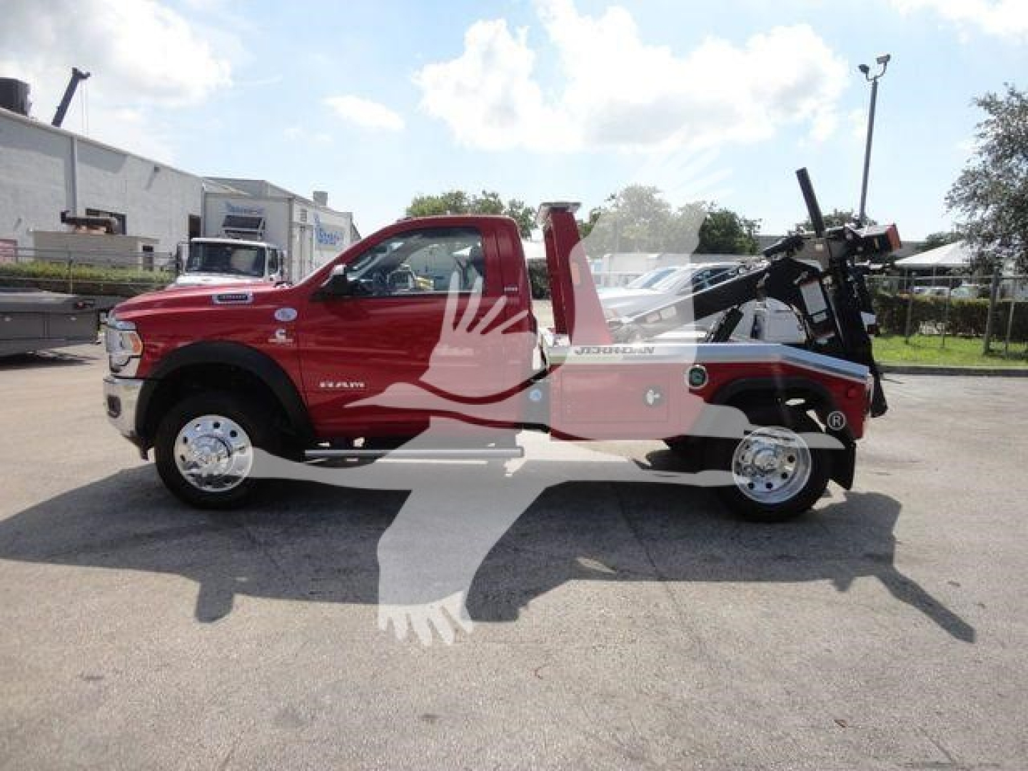 Truck side profile showing a red Ram 4500 SLT with a tow winch bed and equipment mounted in the rear, including a black crane-like device and hydraulic winch.