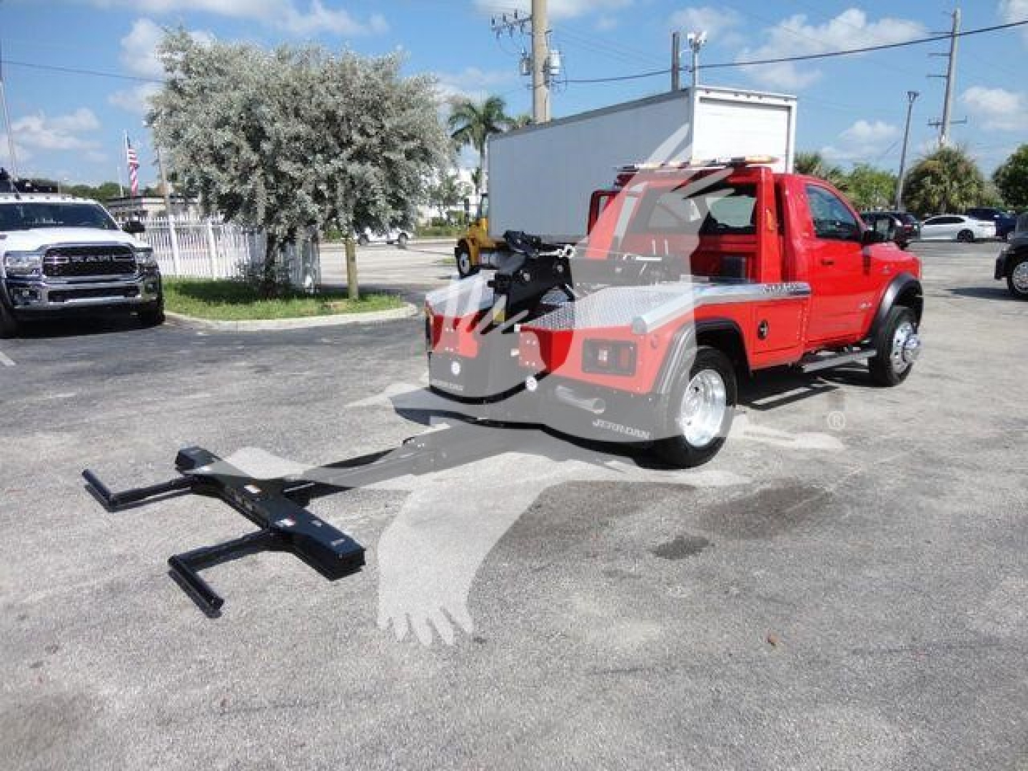 Ram 4500 SLT pickup with winch hitch mounted on the rear, red body, black aftermarket front bumper, in an outdoor lot.