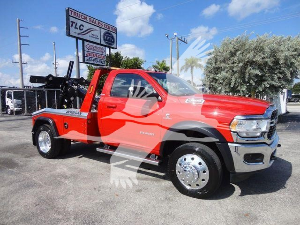 Red Ram 4500 SLT tow truck with crane winch, side view, front chrome bumper, dual rear wheels, TLC sign in background.
