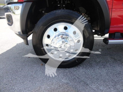 Truck wheel with chrome hubcap and black tire on front fender; partial red body of Ram 4500 pickup and chrome bumper visible