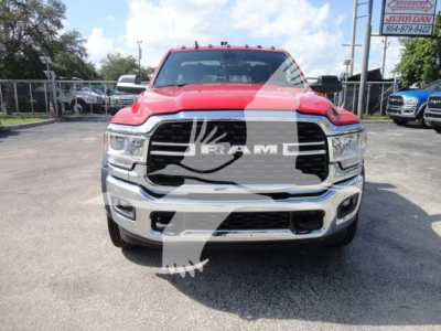 Front view of a red 2024 Ram 4500 SLT pickup truck with large black grille, chrome bumper, and Ram emblem; dealership lot in background.