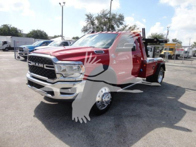 Ram 4500 tow truck/winch-ready chassis showing red exterior, large chrome grille, cab with dual mirrors, with winch equipment and flatbed in cargo area.