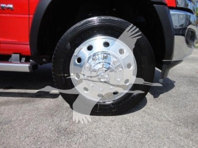 Ram 4500 wheel and front fender close-up showing shiny chrome wheel, black tire, and red body panel of a Ram 4500 SLT truck.