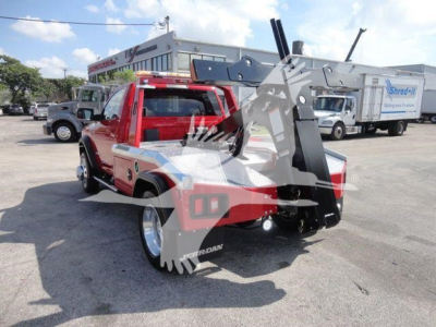Red Ram 4500 pickup with mounted winch equipment in bed, side view showing extended hitch and wheel wells.