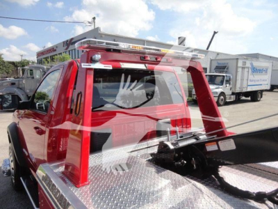 Ram 4500 truck with winch setup and metal diamond plate bed, rear rack and winch line visible.