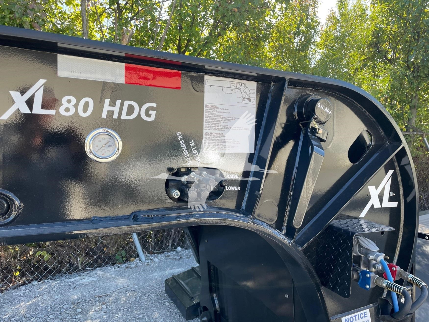 XL Specialized Mini Deck trailer showing XL80 HDG label and hydraulic controls with gauges and warning stickers.