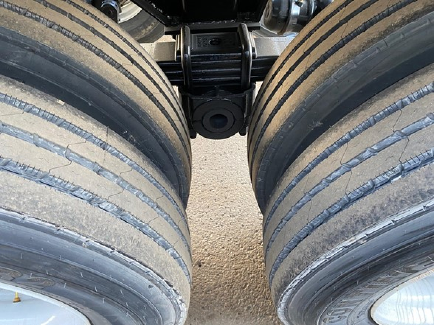 Dual rear axles with dual tires on a Mac Scrap trailer showing suspension components and frame clearance.