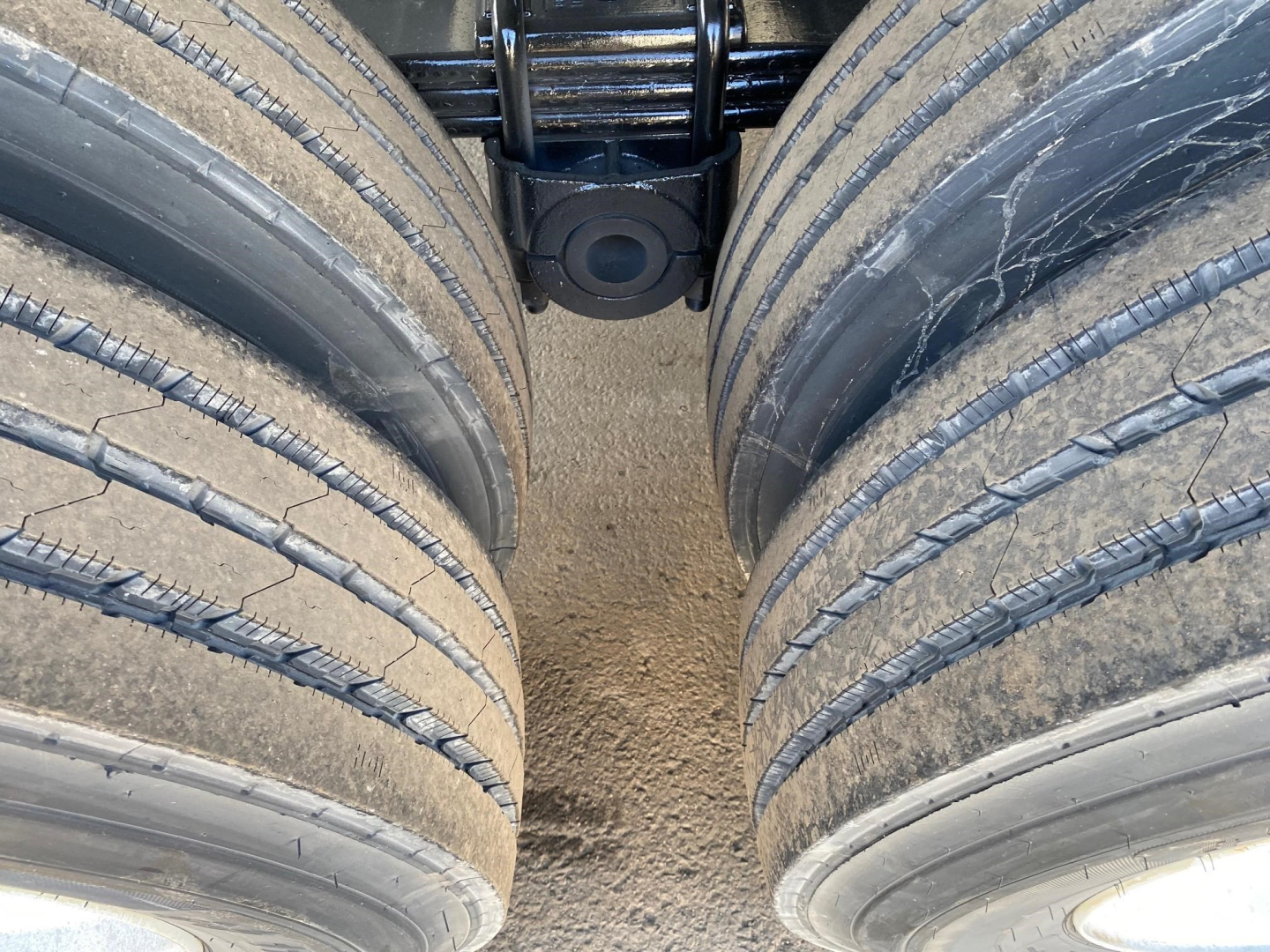 Trailer axles and tires viewed from between dual rear wheels; no visible text on image.