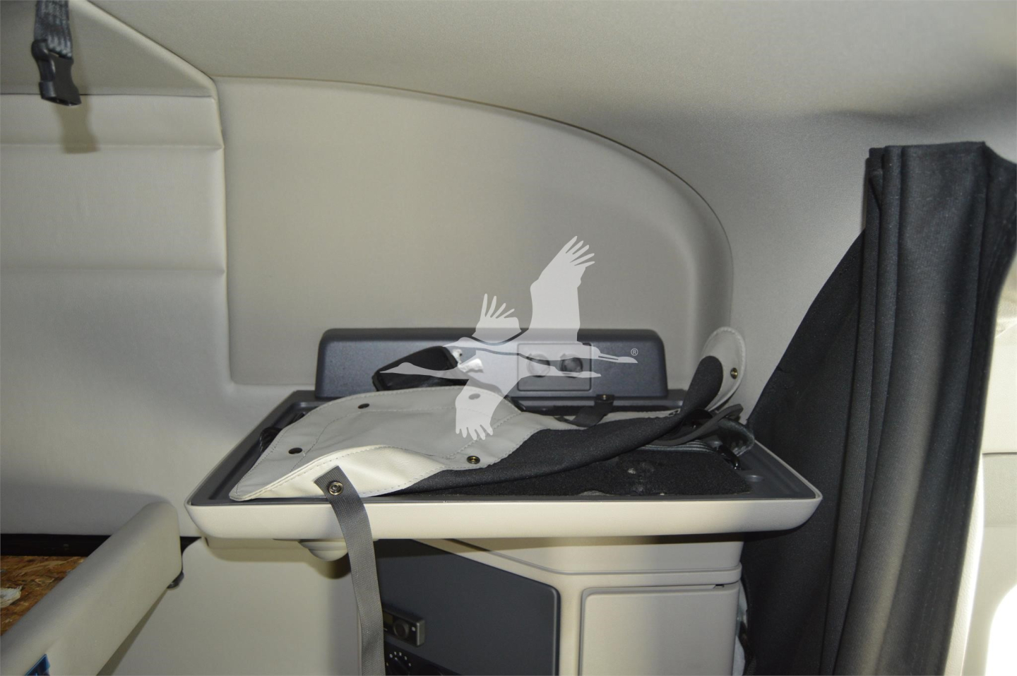 Peterbilt truck interior section showing a fold-out table with a black cushioned surface and light gray interior walls.