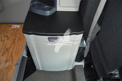 In-vehicle area showing a white/gray cabinet with a black top inside a Peterbilt 579 sleeper cab. Visible text includes a small label and control panel near the cabinet.