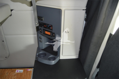 Peterbilt 579 cab interior showing control panel and storage area near passenger seat, 12V power outlet and cup holder visible.
