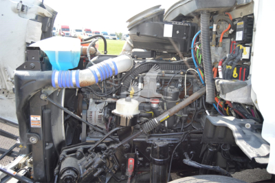 Peterbilt 579 engine bay with wiring, hoses, and components visible; drivetrain and coolant hoses in view.