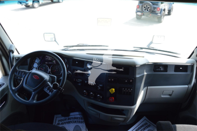 Peterbilt 579 cabin dashboard and steering wheel interior showing instrument cluster and center console.