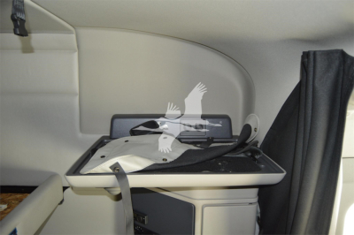 Peterbilt truck interior section showing a fold-out table with a black cushioned surface and light gray interior walls.