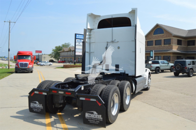 Peterbilt 579 sleeper tractor rear view showing fifth wheel and dual rear axles in a parking lot.