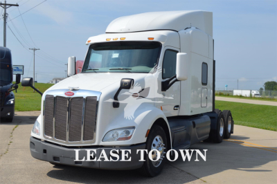 Peterbilt 579 tractor-trailer truck front view with sleeper cab, white exterior, "LEASE TO OWN" text overlay.