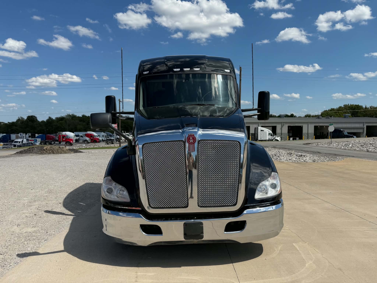 Kenworth T680 front view showing large chrome grille, black hood, and rectangular headlights.