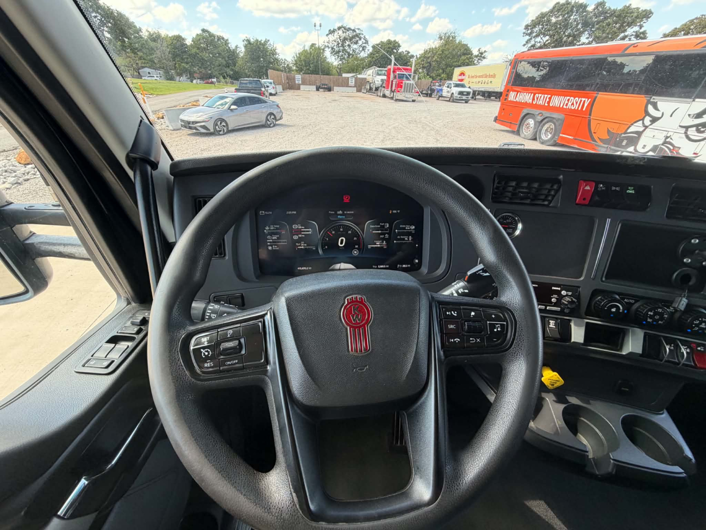 Interior view of a 2022 Kenworth T680 truck cab showing steering wheel with Kenworth logo, instrument cluster, and dashboard controls.