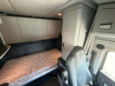Kenworth T680 sleeper cab interior showing bunk bed area and driver seat.