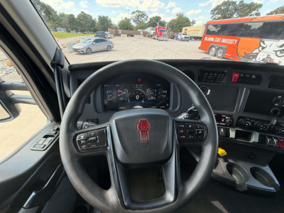 Interior view of a 2022 Kenworth T680 truck cab showing steering wheel with Kenworth logo, instrument cluster, and dashboard controls.