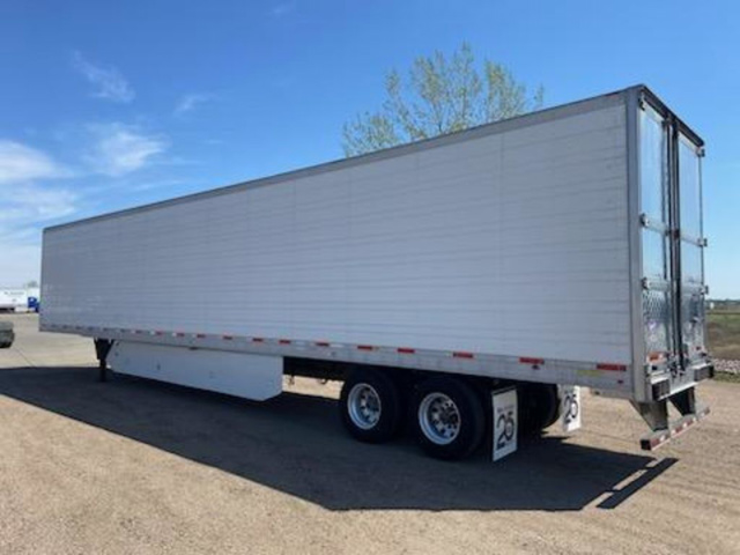 Trailer side view showing a 2017 utility reefer inside a refrigerated trailer with dual rear doors and tandem axle.