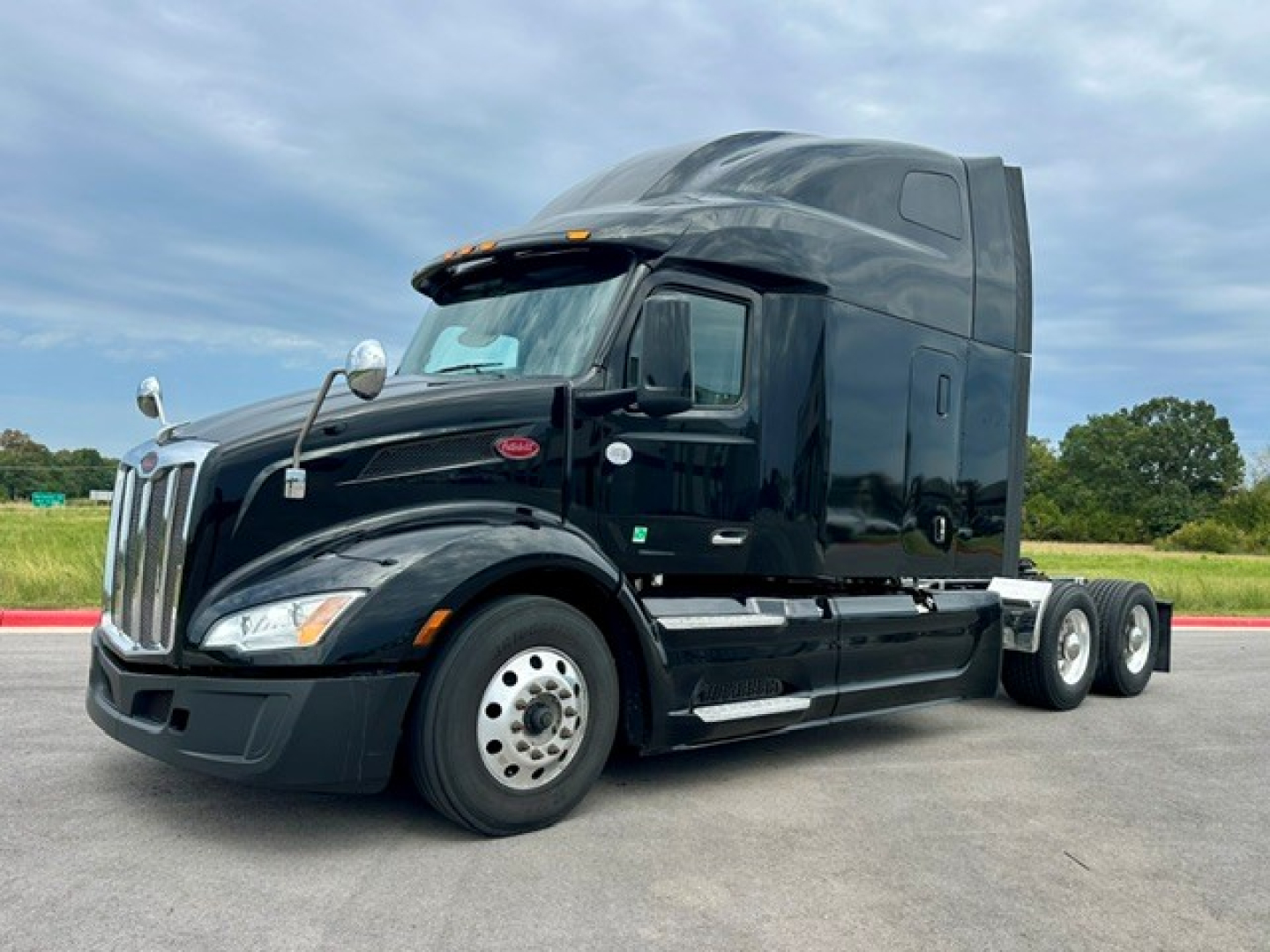Peterbilt 579 tractor in black, three-axle configuration with sleeper cab, front grille, headlamps, and Peterbilt badge visible.