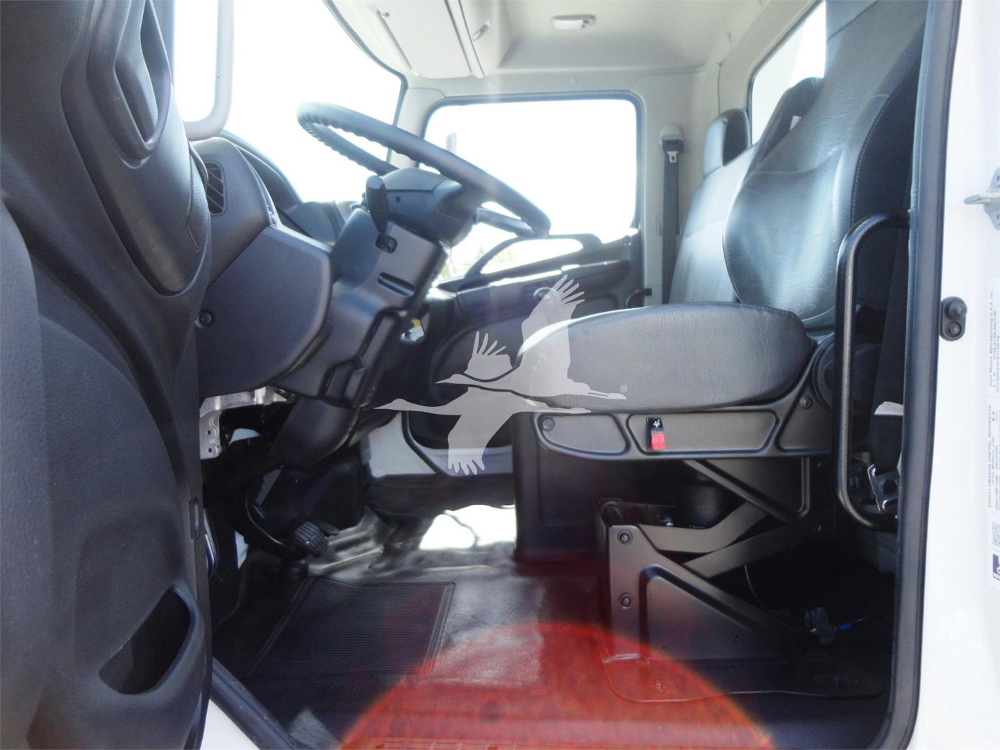 Truck cab interior showing driver seat, steering wheel, and dashboard of a 2022 Hino 268A rollback truck.