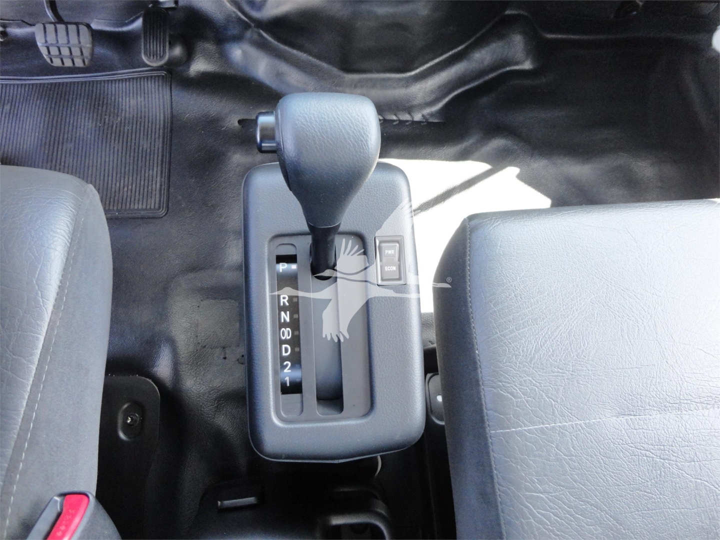 Truck interior with automatic shifter lever showing gear positions R N D 2 1; central console between driver and passenger seats; Ford-style diesel? label not visible.