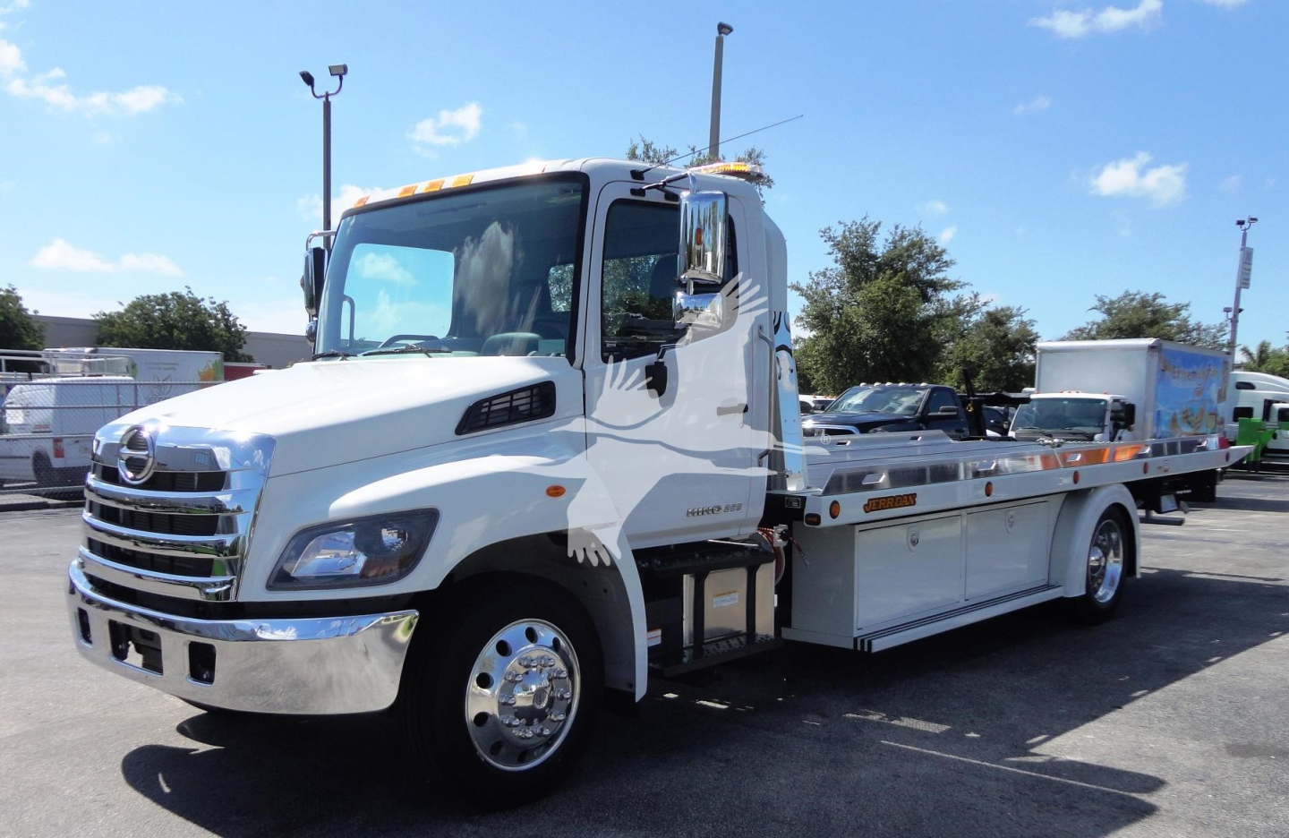 2022 Hino 268A rollback tow truck side view showing cab and flatbed with chrome grille and utility compartments.