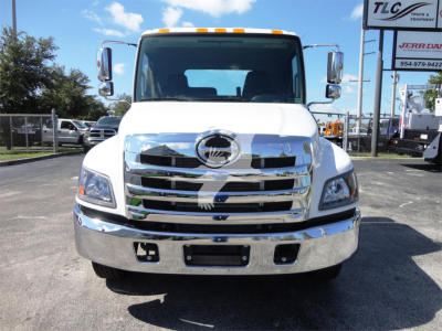 Front view of a white 2022 Hino 268A rollback truck showing chrome grille, Hino emblem, large bumper, and side mirrors.