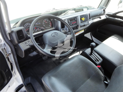 Interior of a 2022 Hino 268A cab showing steering wheel, dashboard gauges, and gear selector.