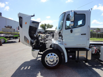 Rear-slash side view of a white 2022 Hino 268A rollback truck with hood open, showing engine bay and front wheel, cab doors visible.
