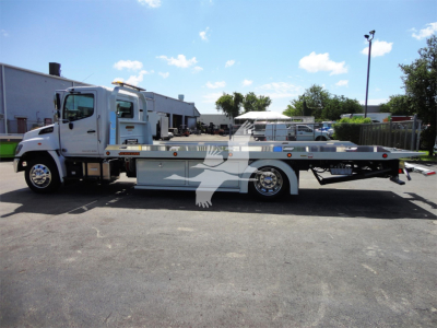 2022 Hino 268A rollback tow truck side view showing flatbed and cab with stock number J51795 in a lot.