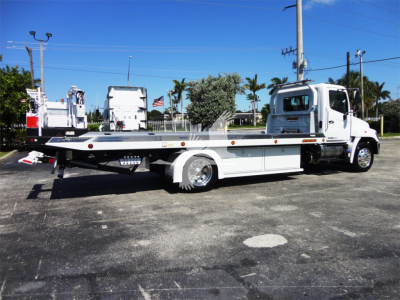 Hino 268A rollback tow truck side view with flatbed and cab, white color, stock number J51795.
