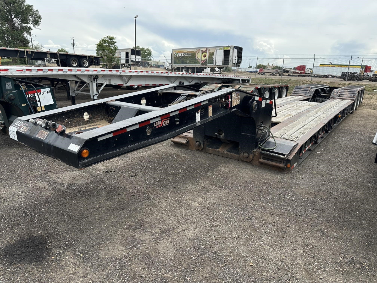 Load King RGn lowboy trailer in a used condition showing long flatbed sections and wheel bunks.