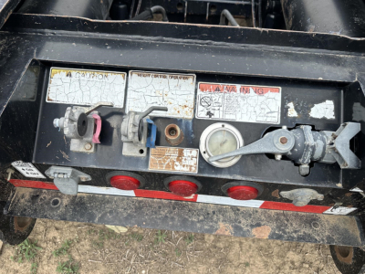 Load King RGN lowboy trailer rear coupler area with labels and control pins visible.